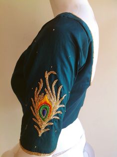 Pure raw silk blouse with peacock feather embroidery on the sleeves.Custom fitted. -Measurements sheet will be sent to you once you order( Standard sizing also available) -Custom colors available -Work on front and back -Sleeves can be added if required Please convo me if you're have any specific requirements. This blouse can be done with or without the bust cup inserts . The blouse is fully lined is cotton. Usual turn around time is 1-2 weeks, but we may be able to accomodate emergency requests Wedding Traditional Wear With Embroidered Sleeves In Chanderi, Bollywood Traditional Wear With Embroidered Sleeves For Festivals, Wedding Traditional Wear With Embroidered Sleeves, Chanderi Traditional Wear With Embroidered Sleeves For Wedding, Traditional Blouse With Embroidered Sleeves For Designer Wear, Fitted Traditional Top With Embroidered Sleeves, Traditional Blouse With Embroidered Sleeves For Festive Season, Festive Wedding Blouse Piece With Embroidered Sleeves, Traditional Blouse With Embroidered Sleeves For Festivals