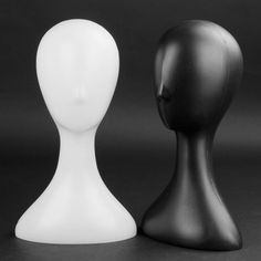 two black and white mannequin heads sitting next to each other