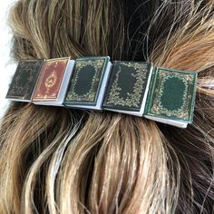 Order now-SHOP CLOSED 8/3/2024-8/19/2024 for summer break!  Be the envy of everyone at book club! Handmade miniature book hair clip set on a French barrette. Five tiny paperback books filled with real pages set on a silver tone hair clip that holds hair securely.       Each clip will have a unique set of books on it.       Miniature paperbacks are somewhat delicate so please handle with extra love, just as you would your favorite book :-)       Total length approximately 3.25" long by 0.8" tall. Gift For Book Lover, Miniature Book, Hair Accessories Clips, French Barrette, Miniature Books, Bookish Gifts, Librarian, Book Lovers Gifts, Book Lover