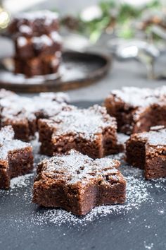 several pieces of brownie sitting on top of a table covered in powdered sugar