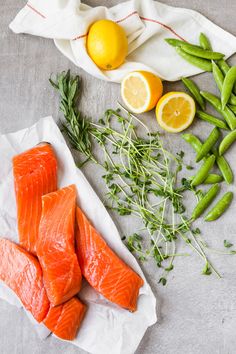 raw salmon, lemons and green beans on a table