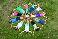 a group of people standing in a circle on top of grass