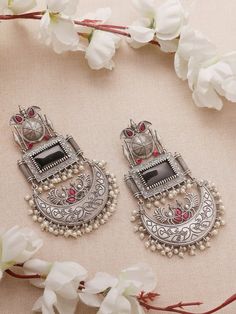 Step into a realm of timeless allure with our Black Pink Earrings, reminiscent of the majestic Chandbalis in stunning silver replica. 

Crafted with meticulous attention to detail, each piece reflects the intricate craftsmanship of eras past, while the vibrant black and pink stones add a touch of sophistication and allure. Whether you're attending a grand affair or seeking to elevate your everyday ensemble, these Chandbalis promise to leave a lasting impression.

Elevate your style effortlessly with these exquisite earrings, capturing the essence of tradition and luxury in every curve and contour. Embrace the opulence of royalty and make a bold fashion statement with our captivating Black Pink Chandbali Earrings, destined to be the crowning jewel of your collection.

In case of any queries Ceremonial Fusion Silver Bridal Earrings, Wedding Chandelier Earrings For Festivals, Silver Chandbali Danglers For Ceremonial, Silver Chandbali Danglers For Ceremonial Occasions, Silver Bridal Earrings For Ceremonial Diwali, Silver Bridal Earrings For Diwali Ceremonies, Ceremonial Chandbali Jhumkas With Oxidized Finish, Ceremonial Chandbali Oxidized Jhumkas, Silver Bridal Earrings For Ceremonial Occasions During Diwali