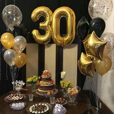 the table is covered with balloons, cake and desserts for an 30th birthday party