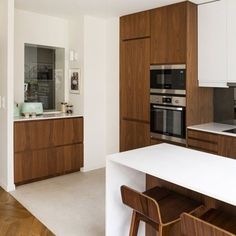 a kitchen with white counter tops and wooden cabinets