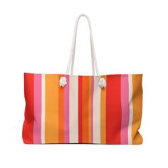 an orange, pink and white striped bag with pom - poms on the handles