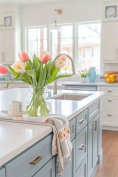 a vase filled with flowers sitting on top of a kitchen counter