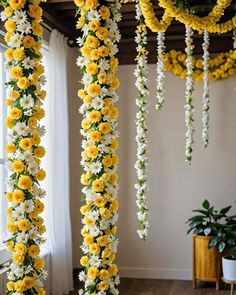 yellow and white flowers are hanging from the ceiling