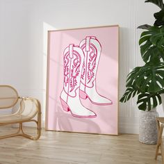 a pink poster with cowboy boots on it in front of a chair and potted plant