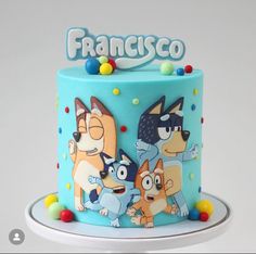 a blue cake decorated with cartoon characters and the word franisco written on top