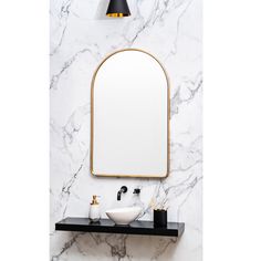 a white sink sitting under a mirror next to a wall mounted faucet in a bathroom