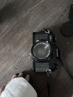 a person holding a camera on top of a wooden table