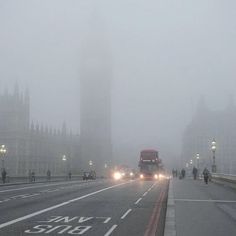 the big ben clock tower towering over the city of london on a foggy day