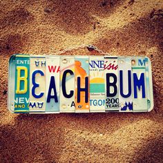 a license plate that says beach bum on the side of a sandy area with sand in the background