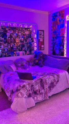 a bed room with a laptop on top of it next to a wall covered in pictures