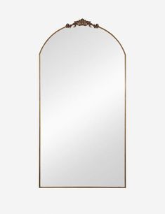 an arched mirror with a gold frame