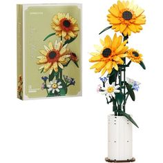 a white vase filled with yellow flowers next to a boxed card and box on a white background