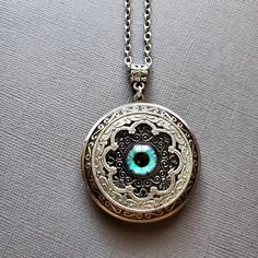 Large Locket Dragon Eye Necklace ☻Locket ~ Large, Decoratively Styled ~ Measures 1.77 inches round See Photos for size comparison against American quarter Chain: ~ Silver Plated YOU CHOOSE YOUR CHAIN LENGTH during checkout ☻More Lockets Here: https://www.etsy.com/shop/FashionCrashJewelry/search?search_query=lockets&order=date_desc&view_type=gallery&ref=shop_search ☻Link to The ENTIRE SHOP: https://www.etsy.com/shop/FashionCrashJewelry?ref=shopsection_shophome_leftnav&ga_search_qu Vintage Round Pendant Jewelry For Festivals, Antique Nickel-free Jewelry For Festivals, Turquoise Round Locket Jewelry, Round Turquoise Locket Jewelry, Green Round Locket Necklace, Blue Engraved Jewelry For Keepsake, Vintage Locket Jewelry For Festivals, Nickel-free Turquoise Circle Jewelry, Spiritual Jewelry With Vintage Charm Round Pendant