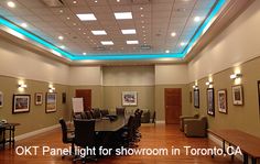 a large conference room with wood floors and lights on the ceiling is lit by recessed lighting