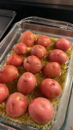 there are many red potatoes in the dish on the stove top, ready to be cooked