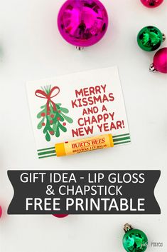 christmas ornament and lip glosses with the text merry kissmas and a happy new year