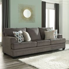 a living room scene with focus on the sofa and pillows, along with rugs