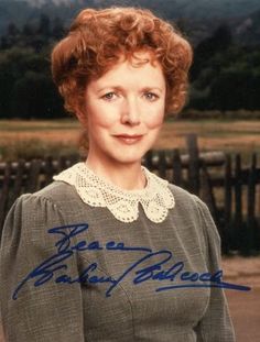 an old photo of a woman with red hair wearing a gray top and white collared shirt