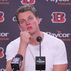 a man sitting in front of microphones at a press conference