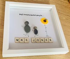 two stones in a shadow box with the words mrs jones and mr jones spelled by scrabbles