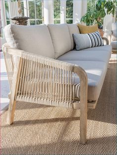 a white couch sitting on top of a wooden floor next to a potted plant