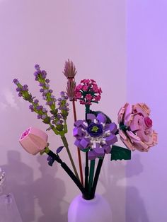 a white vase filled with flowers on top of a table