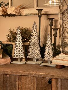 three small christmas trees sitting on top of a wooden table