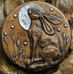 a wooden button with a rabbit on it's face and stars in the background