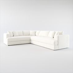 a white sectional couch sitting on top of a white floor