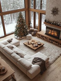 a living room filled with furniture and a christmas tree in front of a fire place