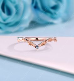 a rose shaped ring with blue topazte in the center and an arrow design on it