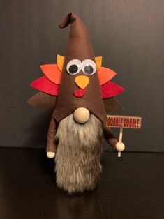 a stuffed turkey holding a sign that says gobble cobble on it's head