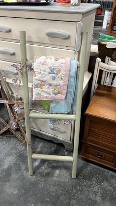 an old dresser with some baby blankets on it