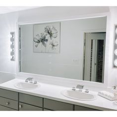 a bathroom with two sinks and a large mirror on the wall above it is shown