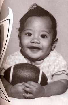 a black and white photo of a baby holding a ball