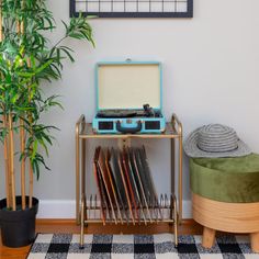 a record player sitting on top of a table next to a potted plant