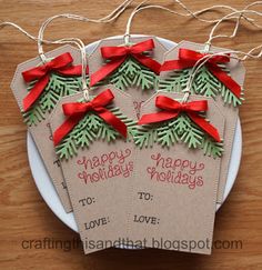 three tags with red bows on them that say happy holidays to love and christmas trees