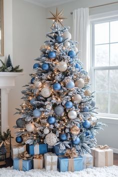 a blue and silver christmas tree with presents under it