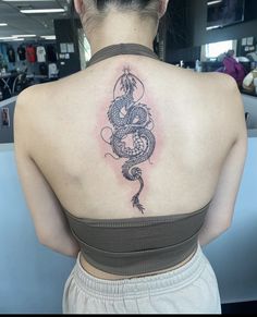 a woman with a dragon tattoo on her back