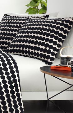 black and white bedding with polka dot print on the sheets, pillowcases and side table