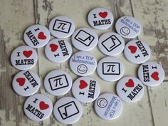 i love maths buttons arranged on a wooden surface with red hearts and other symbols