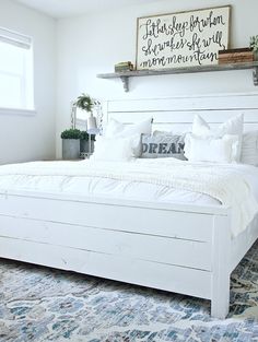 a white bed sitting in a bedroom on top of a blue and white carpeted floor