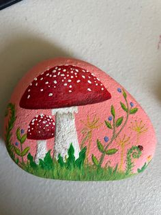 a painted rock with two mushrooms on it