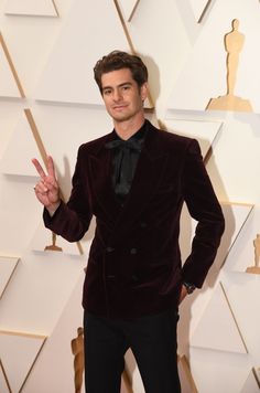 a man in a velvet suit posing for the camera