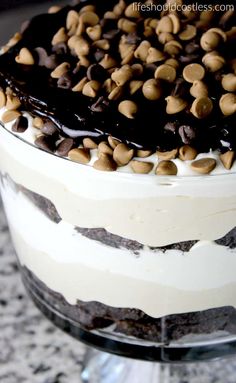 a close up of a cake with chocolate chips on top and frosting in the middle